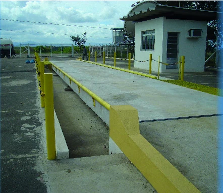 Balança rodoviária de concreto com guarda-corpo amarelo e cabine de controle